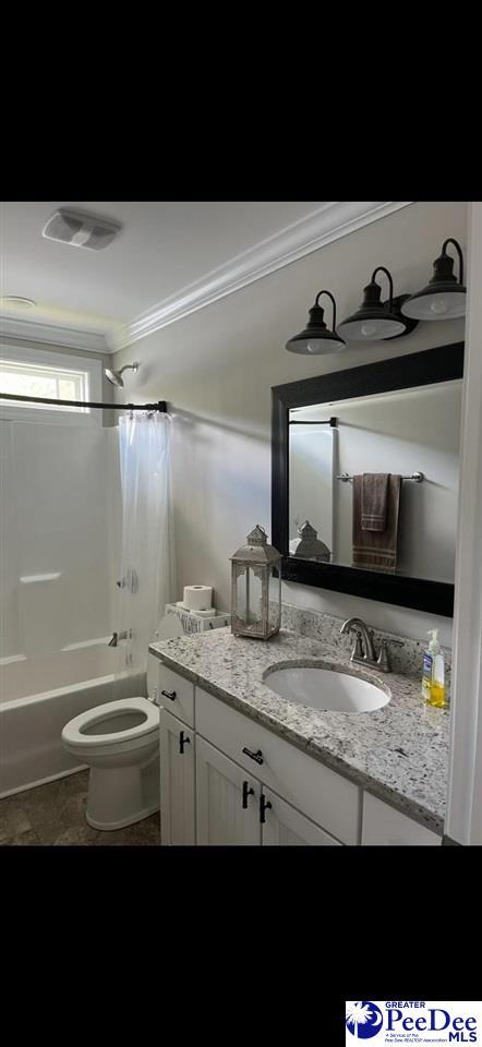 full bathroom featuring vanity, crown molding, toilet, and shower / bath combo with shower curtain