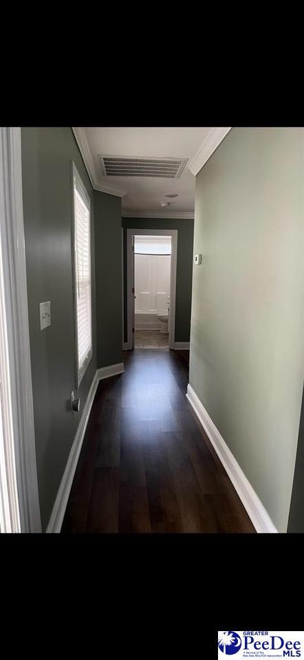 hall featuring crown molding and dark wood-type flooring