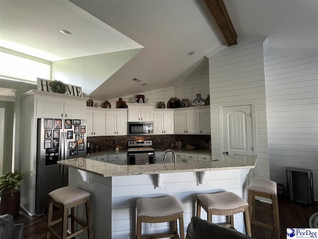 kitchen with white cabinetry, a breakfast bar, stainless steel electric range, and vaulted ceiling with beams