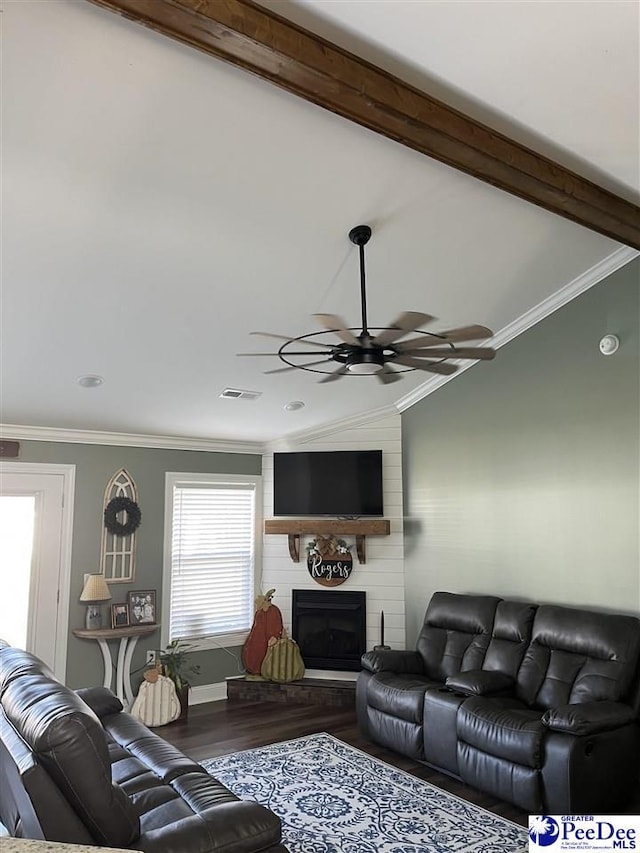 living room with ceiling fan, vaulted ceiling with beams, hardwood / wood-style floors, a fireplace, and ornamental molding