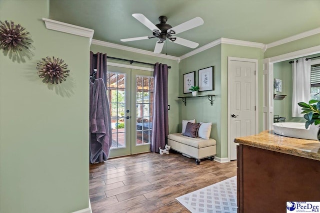 living area with french doors, wood finished floors, baseboards, ceiling fan, and crown molding