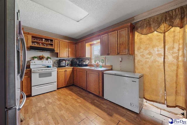903 N Park St, Mullins, SC 29574 - kitchen featuring electric stove, stainless steel fridge, refrigerator, a textured ceiling, and brown cabinets