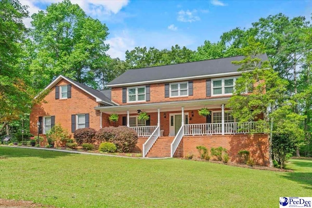 colonial home with covered porch and a front lawn