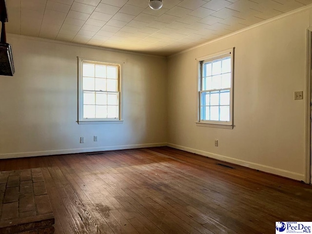 empty room featuring dark wood-type flooring and ornamental molding