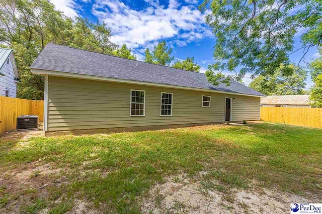 back of house featuring central AC and a yard