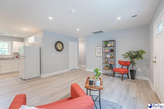 living room with sink and light hardwood / wood-style flooring