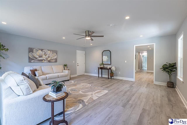 living room featuring ceiling fan and light hardwood / wood-style floors