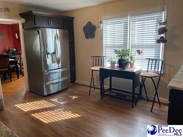 kitchen with dark hardwood / wood-style flooring and stainless steel refrigerator with ice dispenser