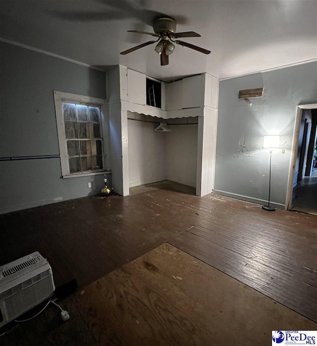 interior space featuring hardwood / wood-style flooring, a wall unit AC, and ceiling fan