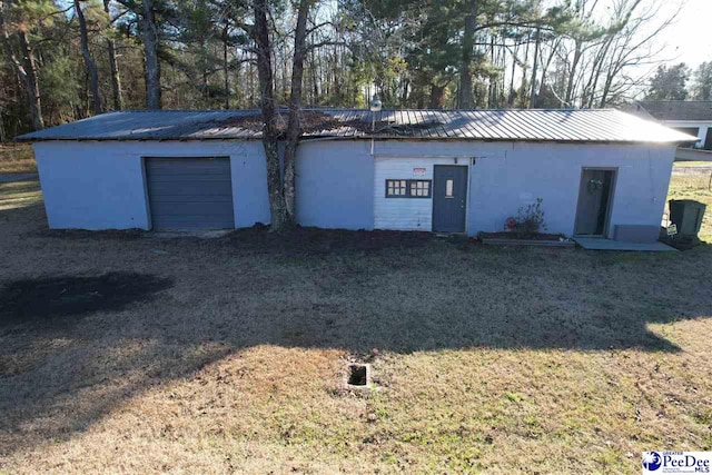 view of outdoor structure featuring a garage and a lawn