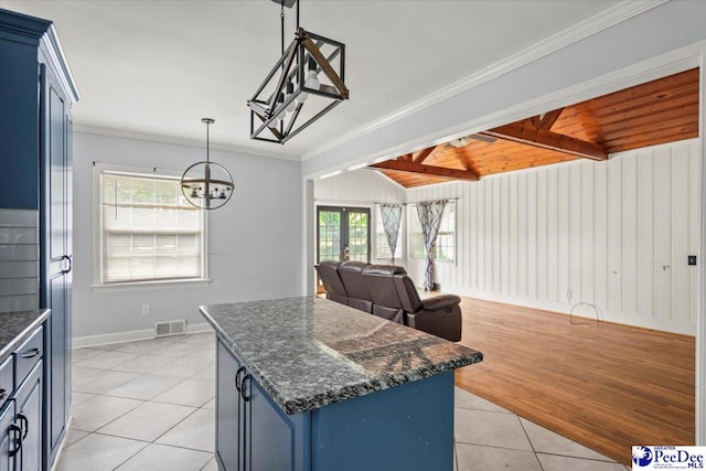 516 S Cashua Dr, Florence, SC 29501 - kitchen with blue cabinets, a chandelier, light tile patterned floors, a center island, and beamed ceiling