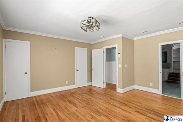 516 S Cashua Dr, Florence, SC 29501 - unfurnished bedroom with light wood-style flooring, ornamental molding, and a chandelier