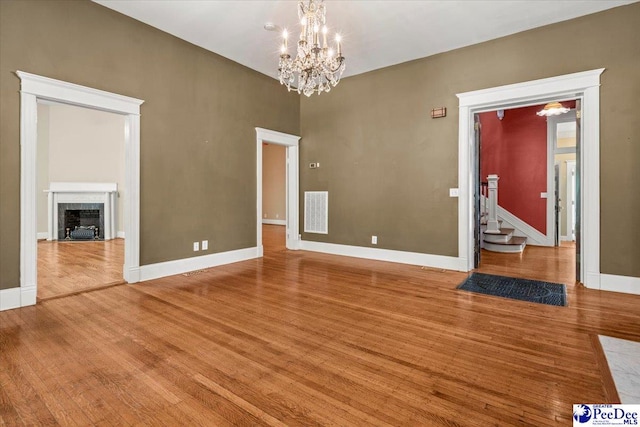 302 Cashua St, Darlington, SC 29532 - spare room with wood finished floors, a chandelier, baseboards, and a fireplace with flush hearth