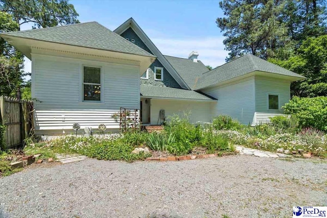 302 Cashua St, Darlington, SC 29532 - rear view of house with roof with shingles, fence, and a chimney