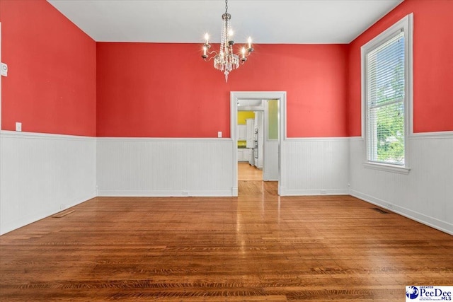 302 Cashua St, Darlington, SC 29532 - unfurnished dining area featuring wood finished floors, a chandelier, and a wainscoted wall