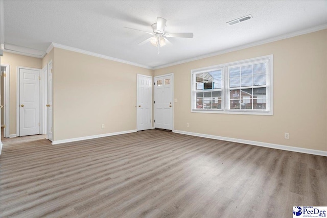 spare room featuring hardwood / wood-style floors, ornamental molding, a textured ceiling, and ceiling fan