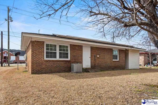 view of front of house featuring central AC unit and a front lawn