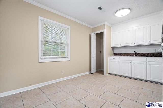 kitchen with white cabinetry, sink, tasteful backsplash, and ornamental molding