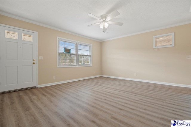 entryway with ceiling fan, ornamental molding, a textured ceiling, and light wood-type flooring