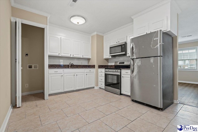 kitchen featuring white cabinetry, appliances with stainless steel finishes, sink, and crown molding