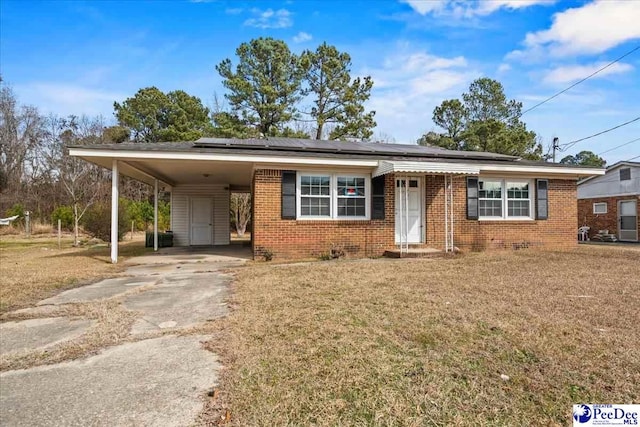 view of front of home with a carport and a front lawn