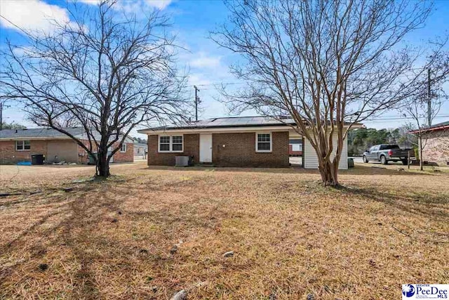 ranch-style home featuring a front lawn and central air condition unit