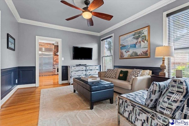 439 Whitman Ave, Florence, SC 29501 - living room featuring light wood finished floors, ornamental molding, ceiling fan, and wainscoting