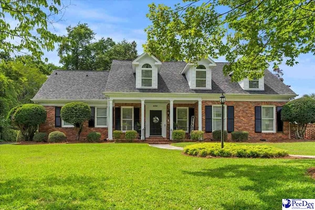 439 Whitman Ave, Florence, SC 29501 - new england style home featuring brick siding, a front lawn, covered porch, and a shingled roof