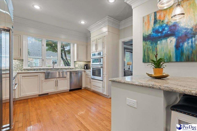 439 Whitman Ave, Florence, SC 29501 - kitchen featuring appliances with stainless steel finishes, light wood-style flooring, decorative backsplash, light stone counters, and recessed lighting