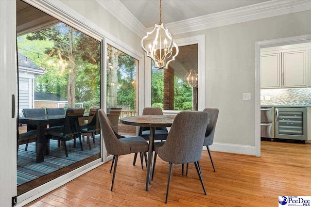 439 Whitman Ave, Florence, SC 29501 - dining space with wine cooler, a chandelier, crown molding, light wood-style floors, and plenty of natural light