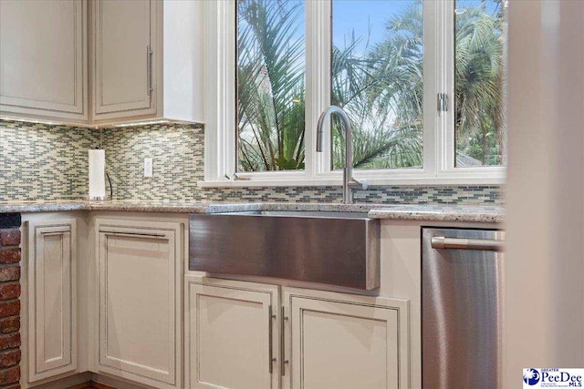 439 Whitman Ave, Florence, SC 29501 - kitchen with decorative backsplash, stainless steel dishwasher, and plenty of natural light