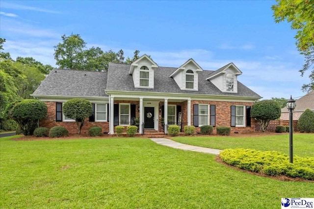 439 Whitman Ave, Florence, SC 29501 - cape cod house featuring brick siding, covered porch, a front lawn, and a shingled roof