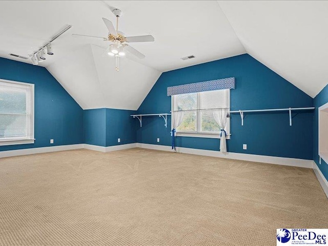 additional living space with vaulted ceiling, carpet flooring, and ceiling fan