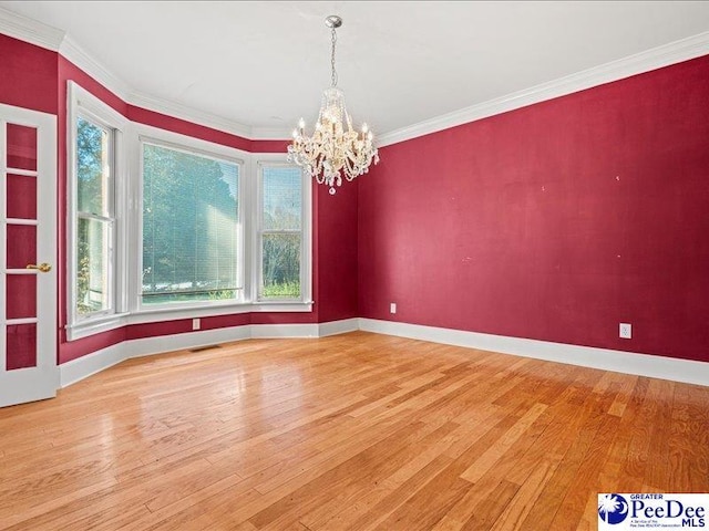 unfurnished dining area featuring ornamental molding, wood-type flooring, and a notable chandelier