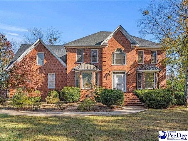 colonial-style house with a front lawn