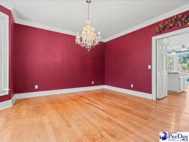 unfurnished room featuring ornamental molding, hardwood / wood-style floors, and an inviting chandelier