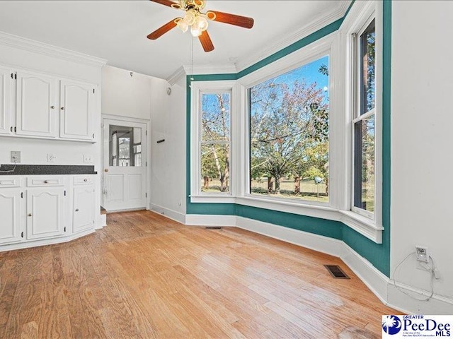 interior space with crown molding, ceiling fan, and light wood-type flooring