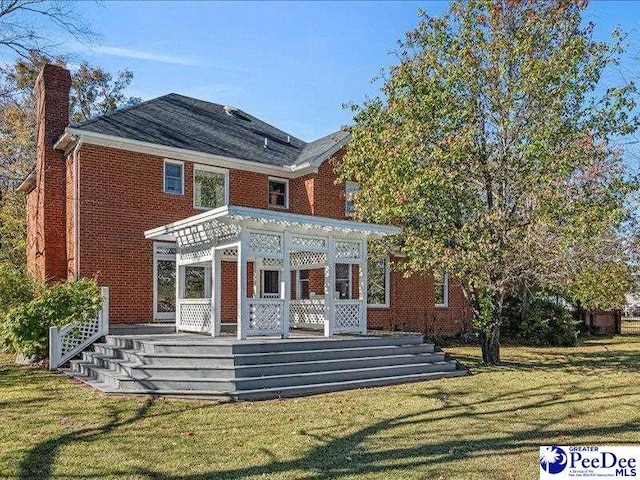 rear view of property featuring a wooden deck, a yard, and a sunroom