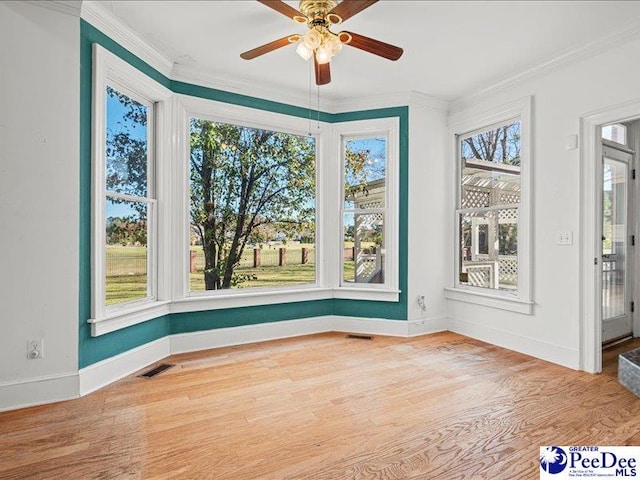 unfurnished sunroom with ceiling fan