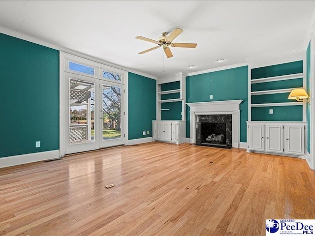 unfurnished living room featuring crown molding, a high end fireplace, and light hardwood / wood-style flooring