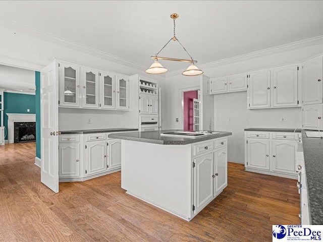 kitchen with cooktop, white cabinetry, and a kitchen island