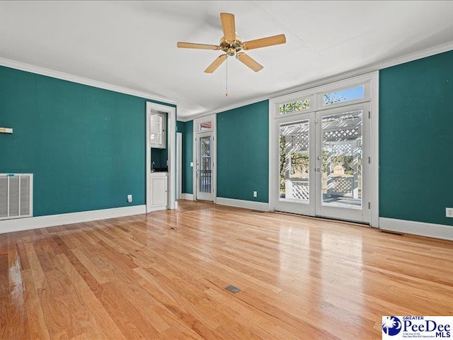 unfurnished living room with hardwood / wood-style floors, crown molding, and french doors