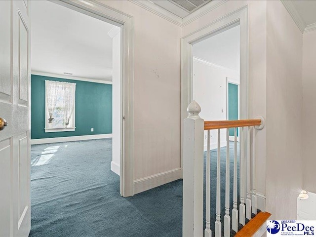 hall with crown molding and dark colored carpet