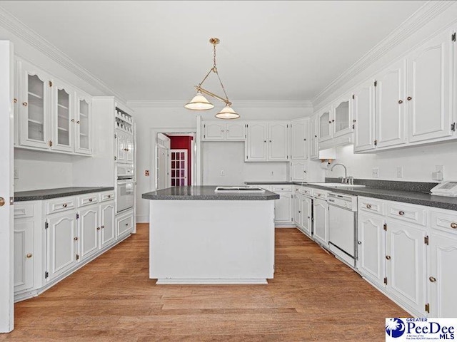 kitchen with white appliances, white cabinetry, ornamental molding, light hardwood / wood-style floors, and a kitchen island