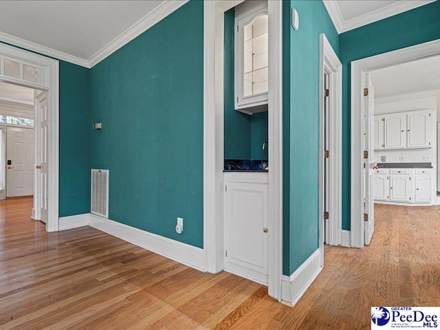 hallway with crown molding and light hardwood / wood-style flooring