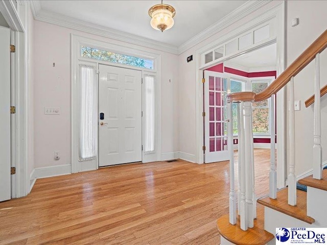 entryway with crown molding, plenty of natural light, and light wood-type flooring