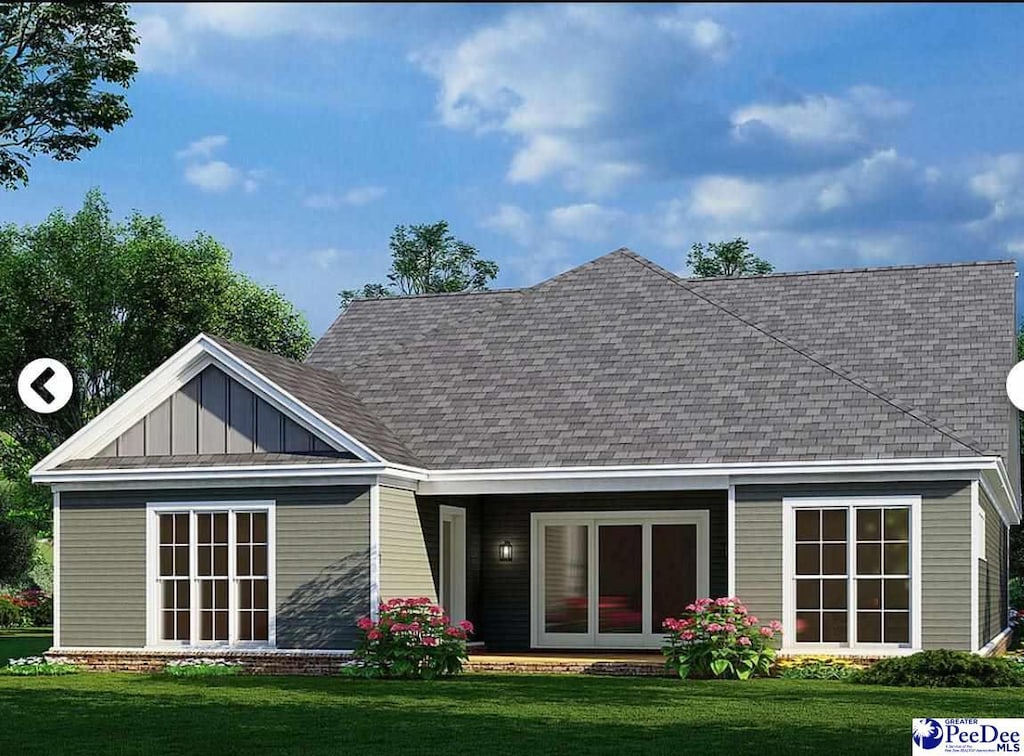 exterior space with a lawn, board and batten siding, and roof with shingles