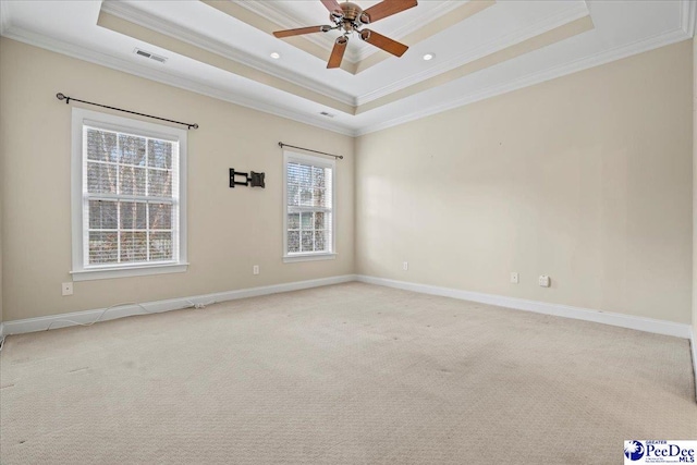 unfurnished room featuring light carpet, a tray ceiling, and ornamental molding