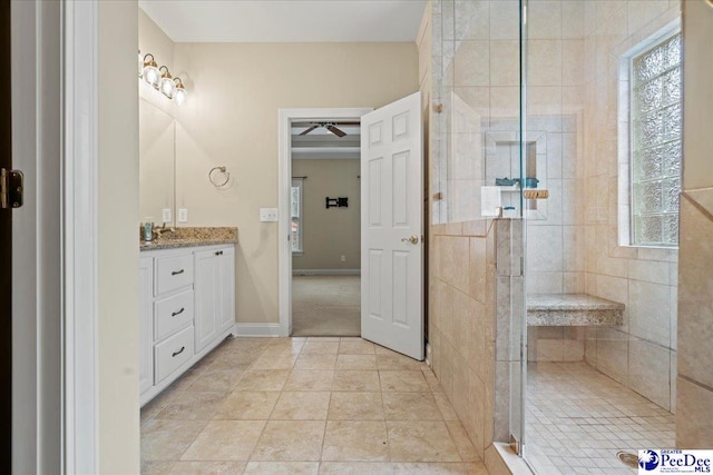 bathroom featuring vanity, a shower with shower door, and tile patterned flooring