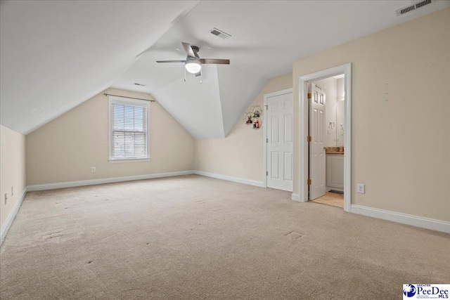 bonus room with ceiling fan, lofted ceiling, and light carpet